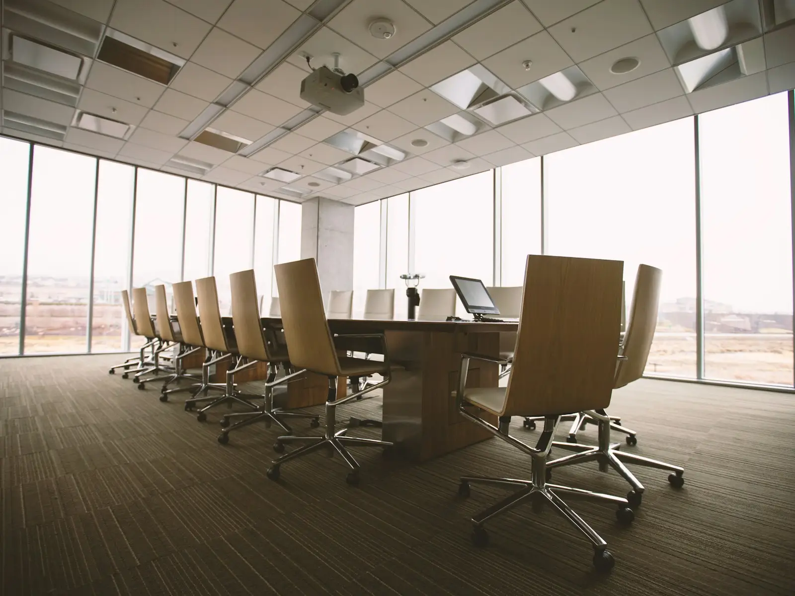 Sala de reuniões corporativa com mesa extensa e ampla iluminação natural